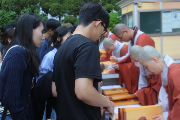 ▲수계법회가 끝나고 수계증과 단주를 받아가는 참석자들 (사진=고아름 수습기자.)