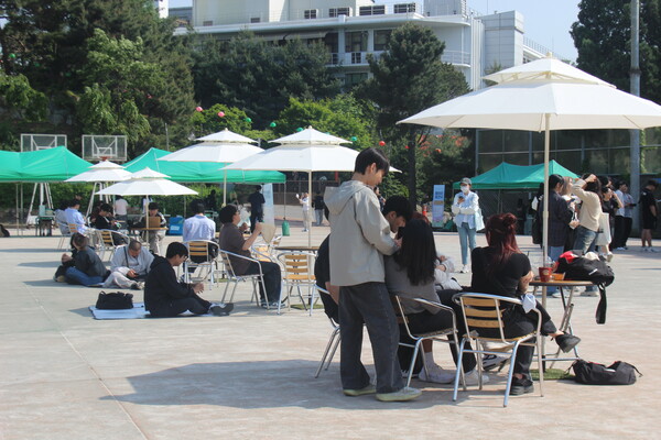 ▲파라솔 아래에서 동아리 공연을 즐기고 있는 학우들의 모습 (사진=임지연 기자.)