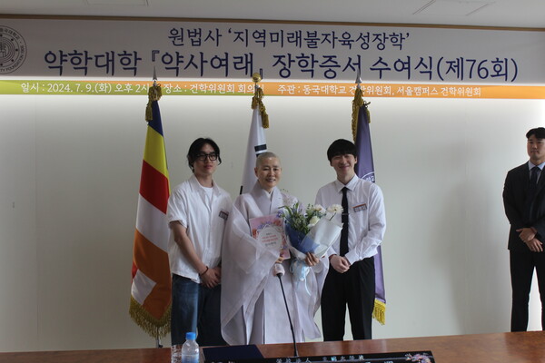 ▲약학대학 ‘약사여래’ 장학생이 해운스님에게 감사편지와 꽃다발을 전달하는 모습이다 (사진=임지연 기자.)