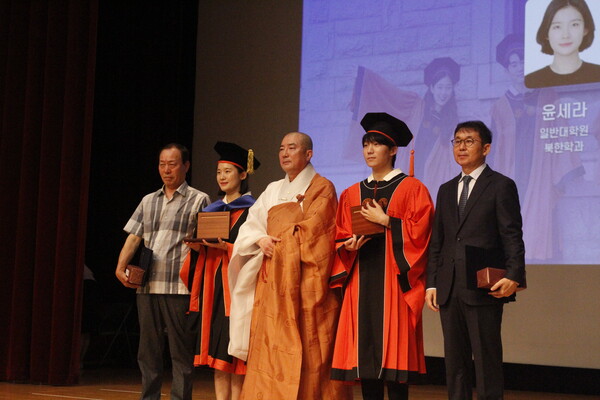 ▲우리대학 이사장 돈관스님이 졸업생들에게 공로상을 수여하고 있다 (사진=오은빈 기자.)
