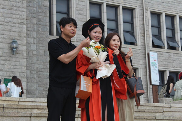 ▲명진관 앞에서 가족들과 기념사진을 찍는 학우들 (사진=오은빈 기자.)