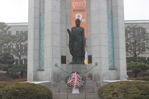 ▲동판 앞에 세워진 제막식 축하 화한 (사진=김지윤 수습기자.)
