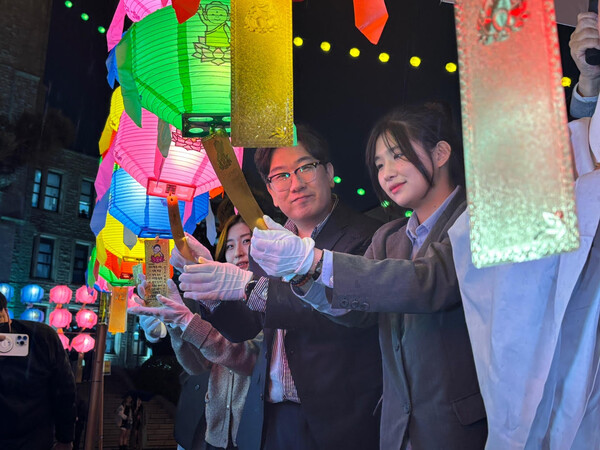 The Student Council president hangs a wish tag on a lantern at the Dongguk Lantern Festival. / Photography by Ku Ji-won
