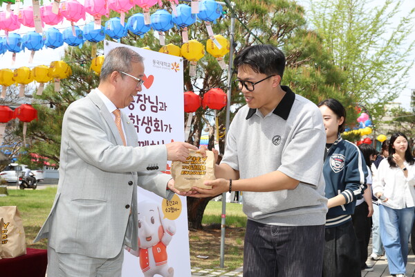▲윤재웅 총장이 직접 포장한 간식을 학생들에게 전달하고 있다 (사진제공=동국대학교.)